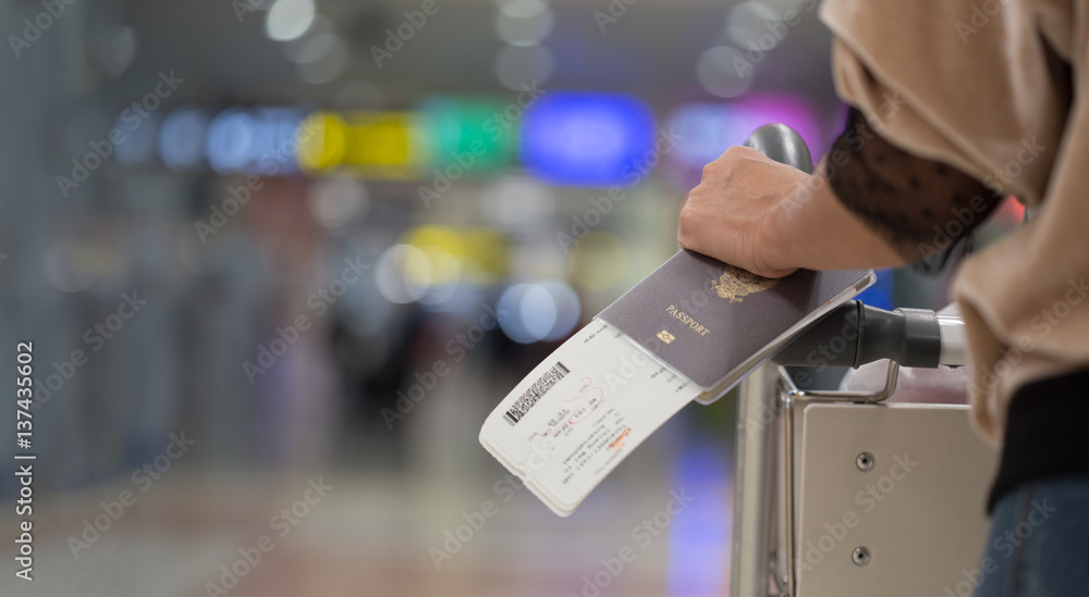 Closeup of girl  holding passports and boarding pass at airport - obrazy, fototapety, plakaty 