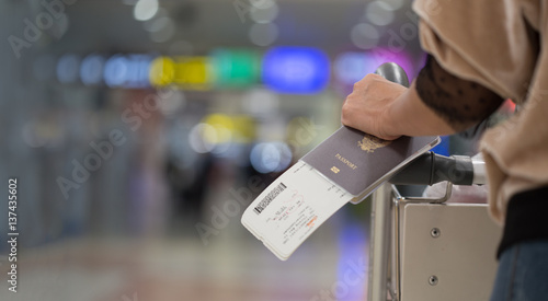Closeup of girl  holding passports and boarding pass at airport photo