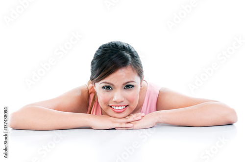 Happy young woman resting her chin on hands over white background