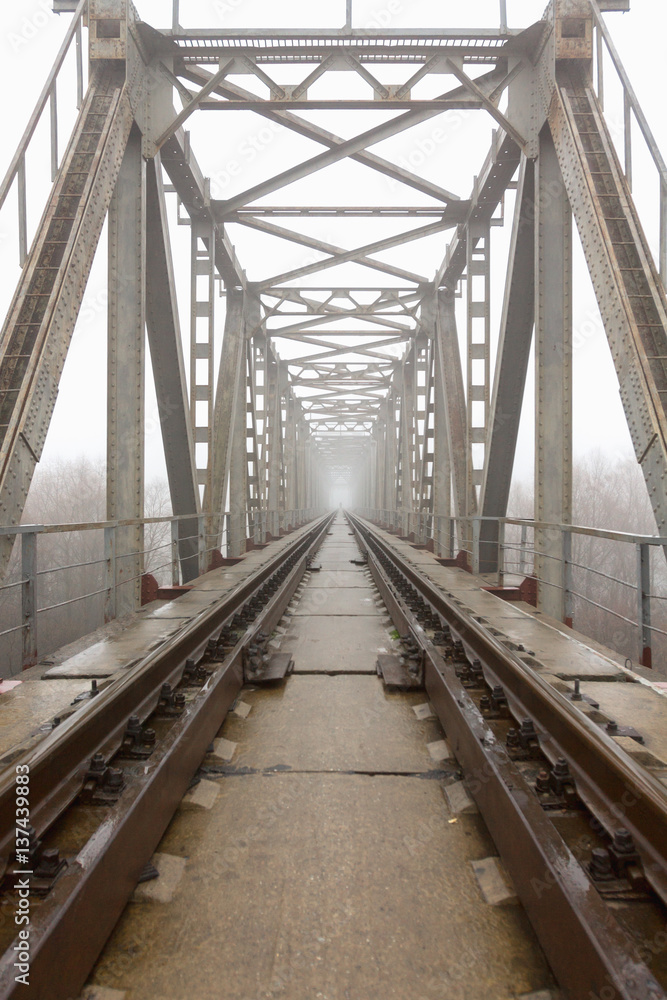 railroad goes into the mist. gray misty autumn morning.
