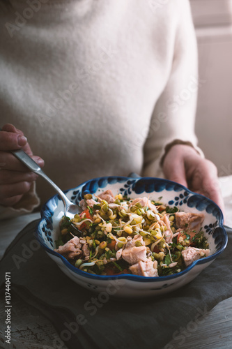 Woman eating a salad with chicken and beans photo