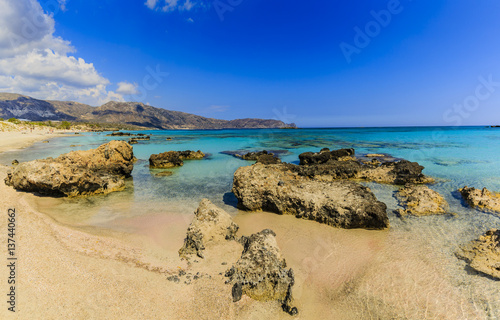Fototapeta Naklejka Na Ścianę i Meble -  Pink sand beach of famous Elafonisi - Elafonissi. The wave of the sea and beautiful beach with cliffs. Coast of Crete island in Greece.