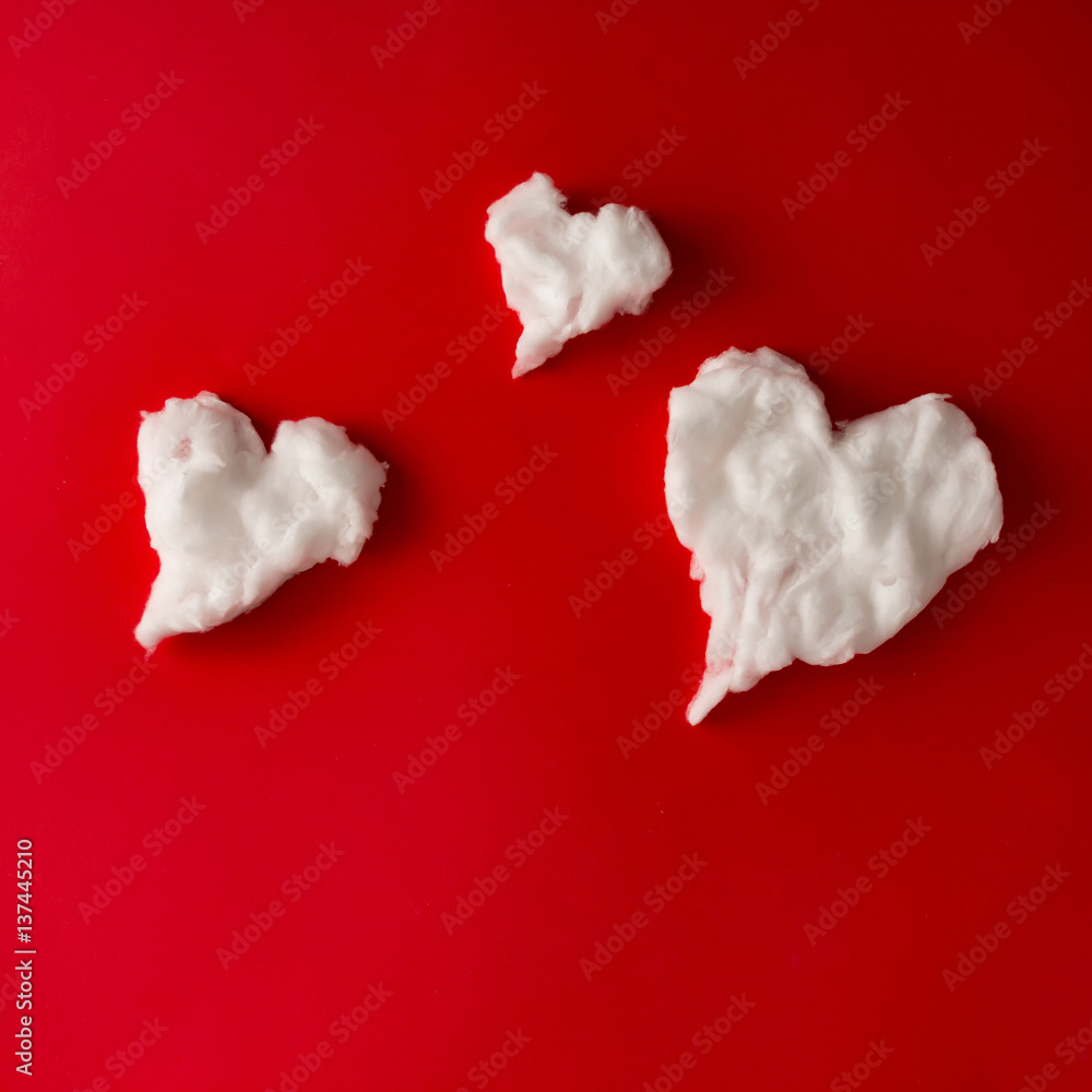 Heart shape white fluffy clouds on red background. Love concept. Flat lay.