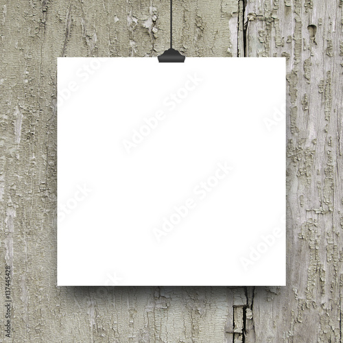 Blank square frame with clip against old weathered wooden background