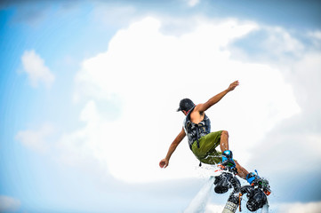 Acrylglasbilder Wasser Motorsport Flyboarder schwebt über blauem Wasser  © sucharn