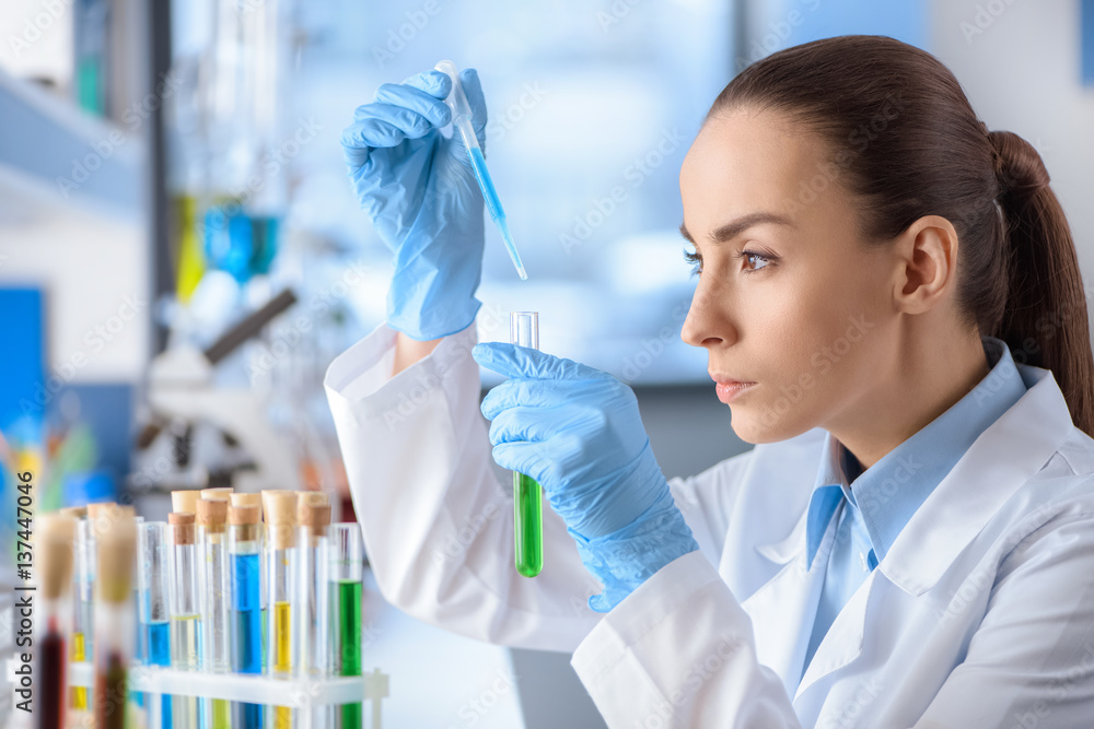 side view of concentrated scientist working with laboratory tube side view of concentrated scientist working with laboratory tube
