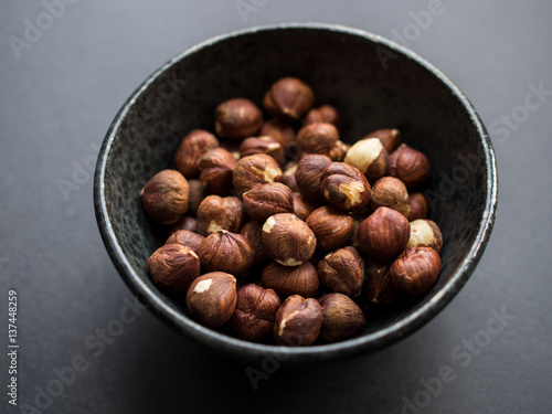 Hazelnuts in bowl isolated on dark background