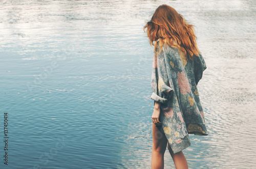 Young red hair woman walking at river alone wearing long cardigan Fashion Lifestyle concept and melancholy depression emotions