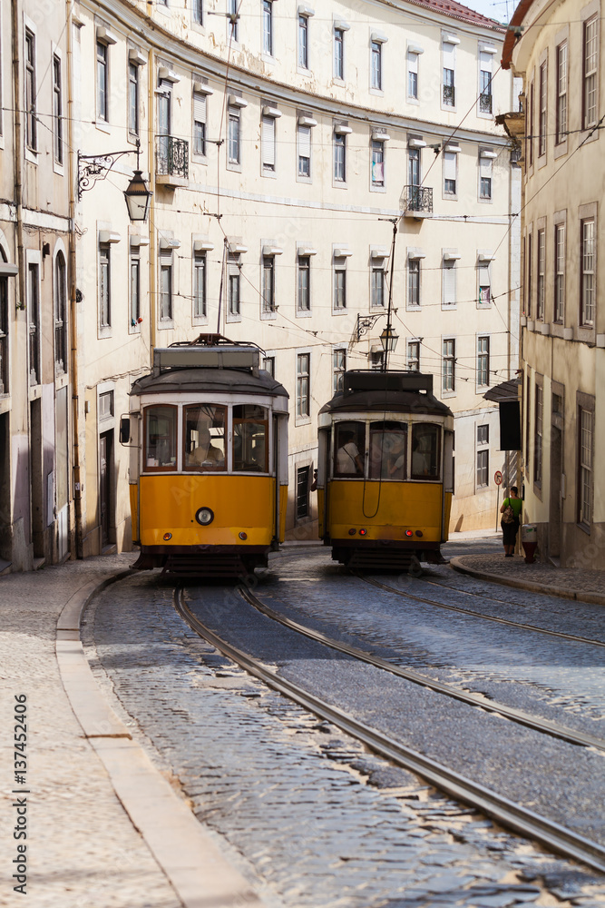 Vintage yellow tramway in Lisbon, Portugal. Bright tram on neutral background building. Tram edit up