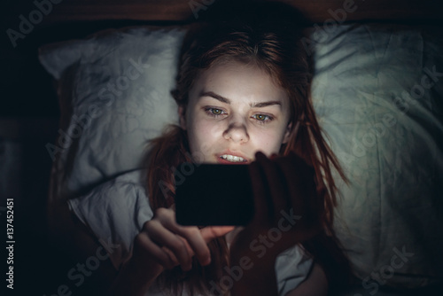 woman looking into the phone, dark background