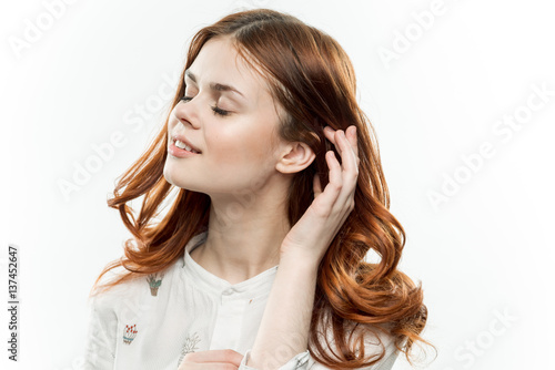 woman with her eyes closed pulls her hair back