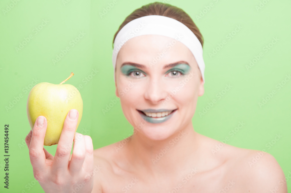 Attractive smiling woman showing healthy apple Attractive smiling woman showing healthy apple