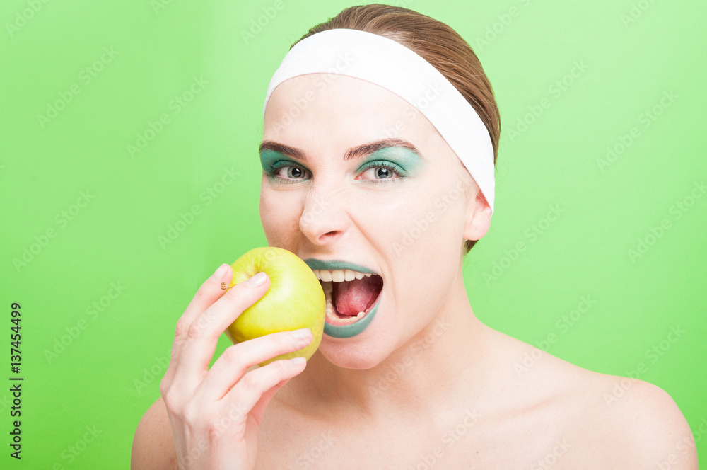 Woman tries to bite a fresh apple Woman tries to bite a fresh apple