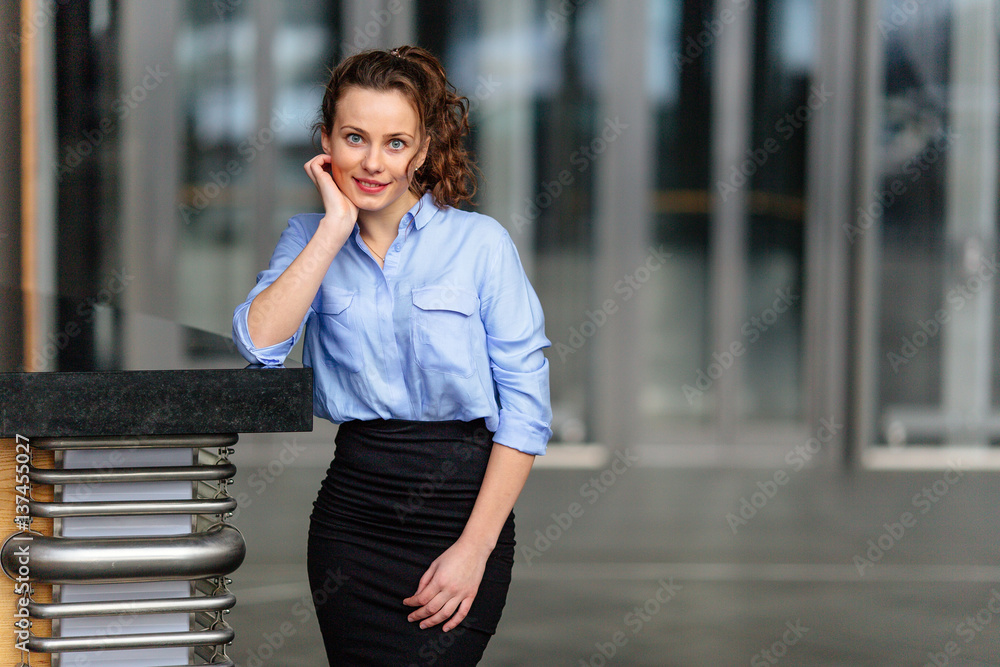 Business girl standing in office building and looking forward
