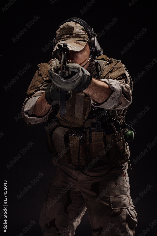 Portrait soldier or private military contractor holding sniper rifle. war, army, weapon, technology and people concept. Image on a black background. Portrait soldier or private military contractor holding sniper rifle. war, army, weapon, technology and people concept. Image on a black background.