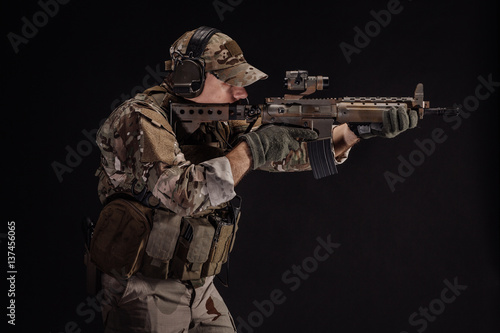 Portrait soldier or private military contractor holding sniper rifle. war  army  weapon  technology and people concept. Image on a black background.