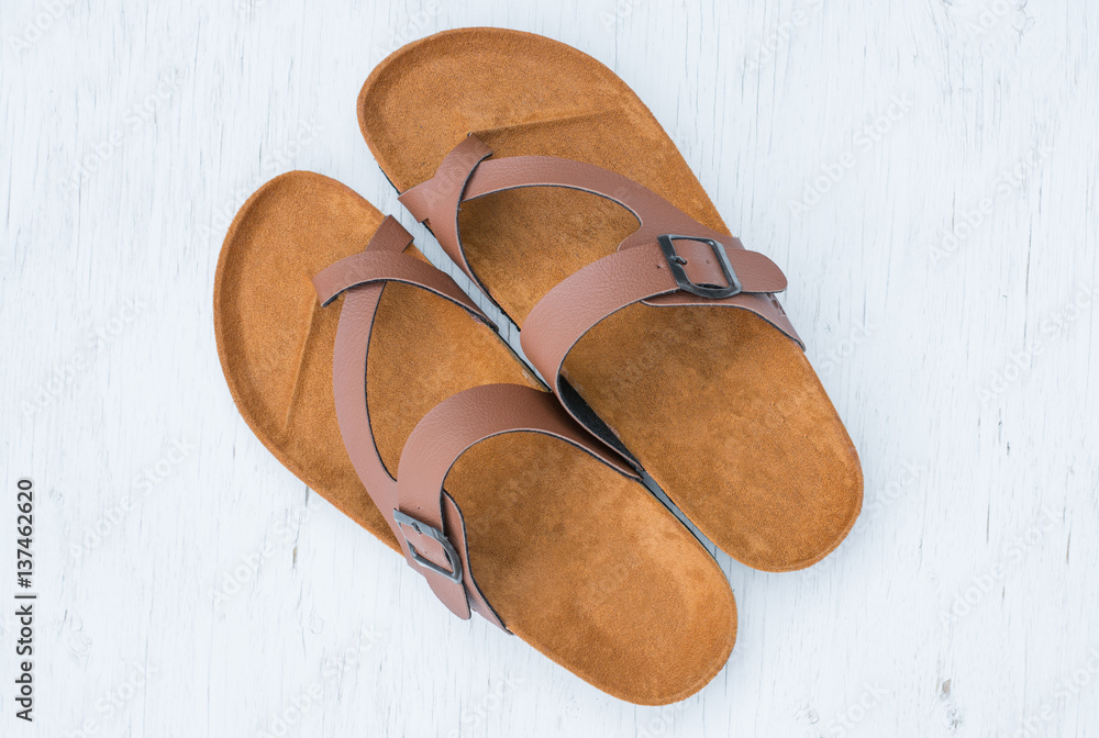 Men's sandals top view on rustic wood background. Photos | Adobe Stock