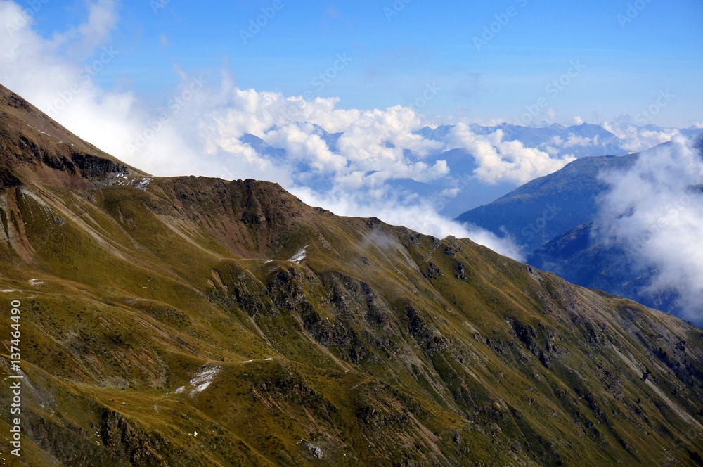 Karge, schöne, grüne Berglandschaft mit Wolken und blauem Himmel Karge, schöne, grüne Berglandschaft mit Wolken und blauem Himmel