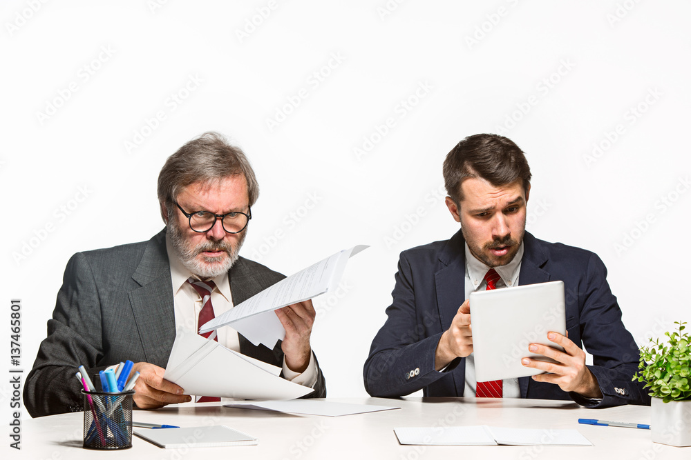 The two colleagues working together at office on white background. The two colleagues working together at office on white background.