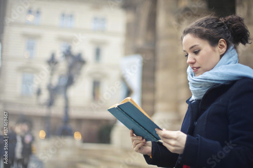 Young woman reading in the street