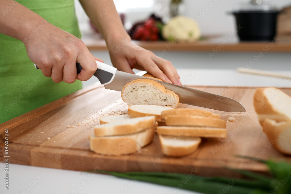 Close up of  woman's hands cooking in the kitchen. Housewife slicing ​​white bread. Vegetarian and healthily cooking concept