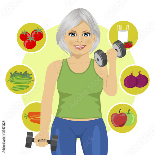 elderly woman with dumbbells and variety of healthy vegetables