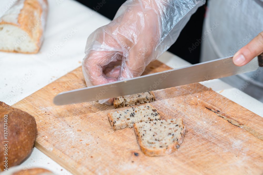 chef slicing bread in th kitchen chef slicing bread in th kitchen