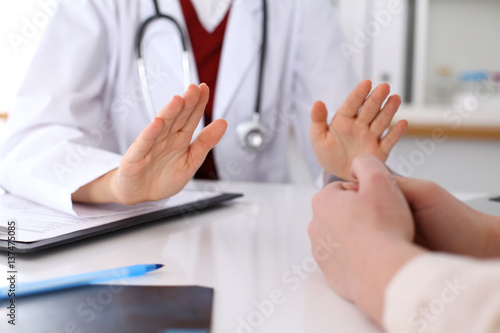 Hand of doctor  reassuring her female patient. Medical ethics and trust concept