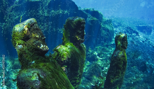 Movie props statues covered in green moss in freshwater spring photo