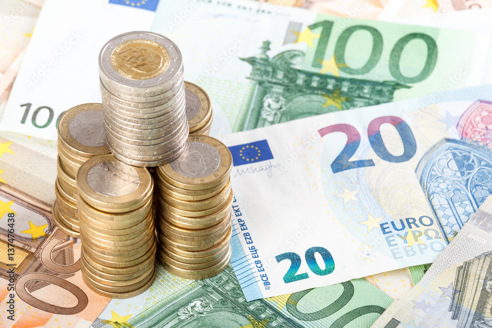 Euro coins stacked on euro banknotes background. Euro coins stacked on euro banknotes background.