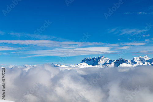 Mountains covered with snow and surrounded by clouds © kenzie