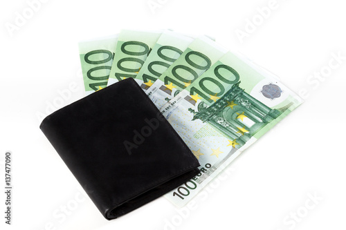 Black wallet on several hundred euro banknotes, on white background.