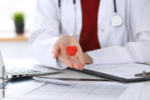 Unknown female doctor with stethoscope holding heart. Children's cardiology and medical care, stop abortation concept photo