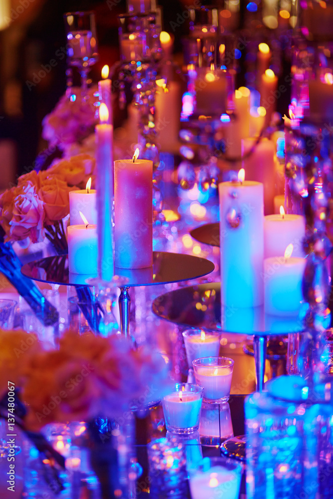 Table set with candles for a festive event, party or wedding reception, in purple light