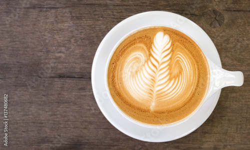 Top view of hot coffee latte art on wood table