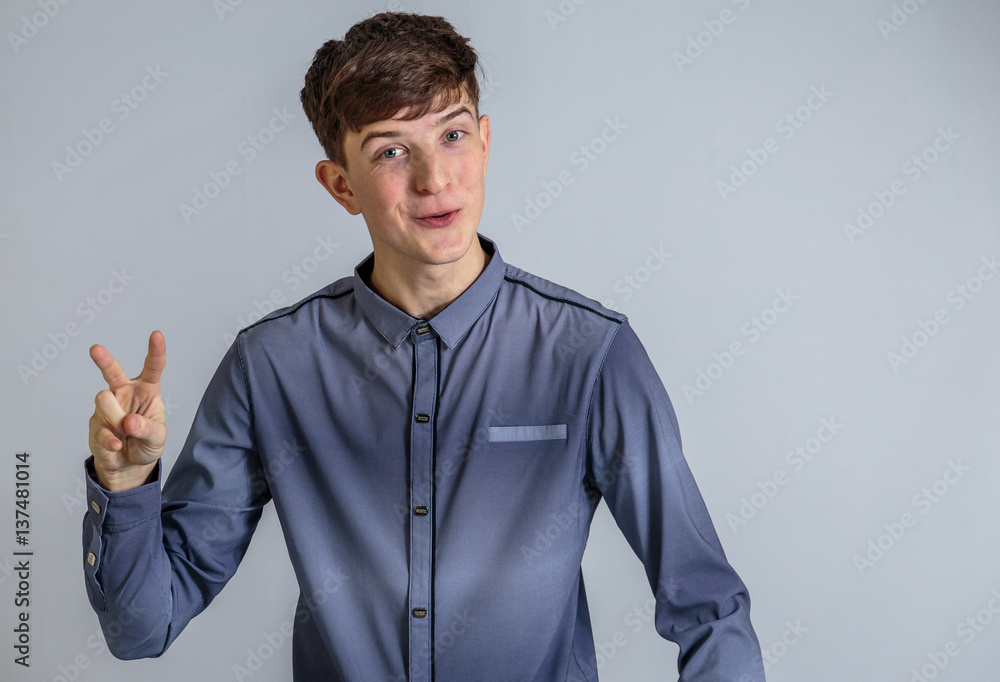 Cheerful guy in a shirt posing on a light blue background Cheerful guy in a shirt posing on a light blue background