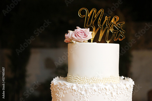 Elegante torta bianca con scritto mr&mrs con rosa affianco photo