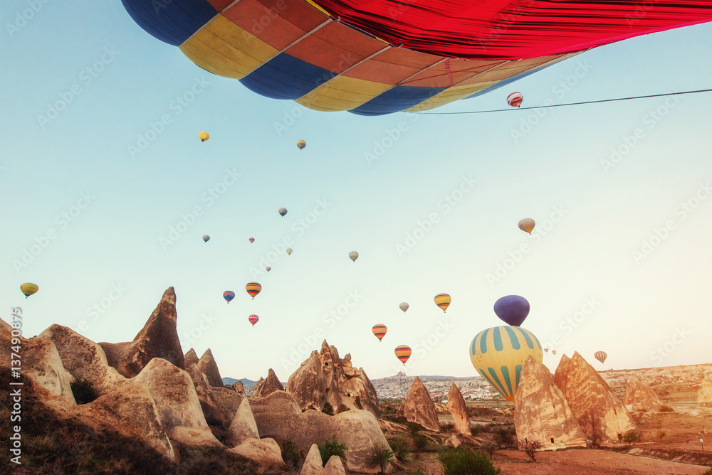 Fototapeta premium Hot air balloon flying over rock landscape at Turkey. Cappadocia