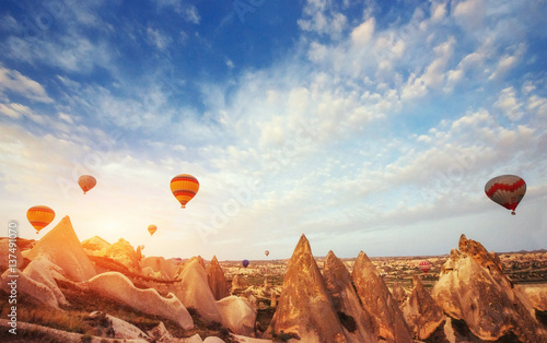 Hot air balloon flying over rock landscape at Turkey. Cappadocia