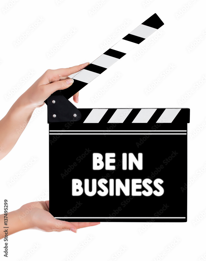 Hands holding a clapper board with BE IN BUSINESS text
