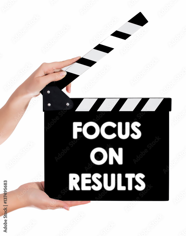Hands holding a clapper board with FOCUS ON RESULTS text