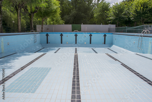 Billede på lærred Empty swimming pool with metal ladder.