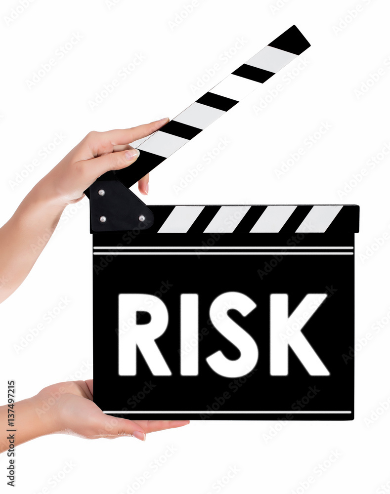 Hands holding a clapper board with RISK text