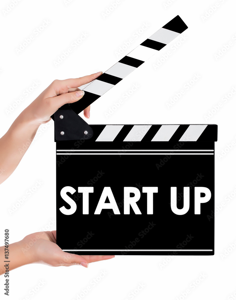Hands holding a clapper board with START UP text