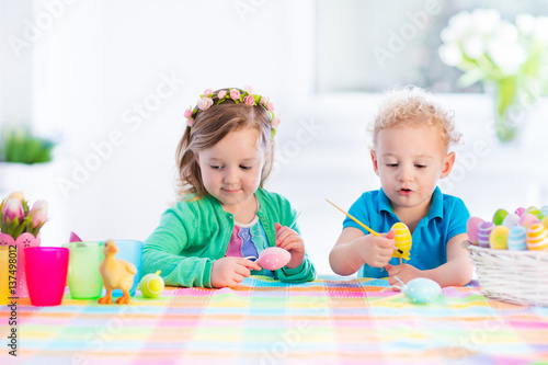 Kids with colorful Easter eggs on egg hunt