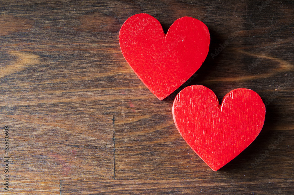 Two red wooden heart on a wooden background. Space for text Two red wooden heart on a wooden background. Space for text