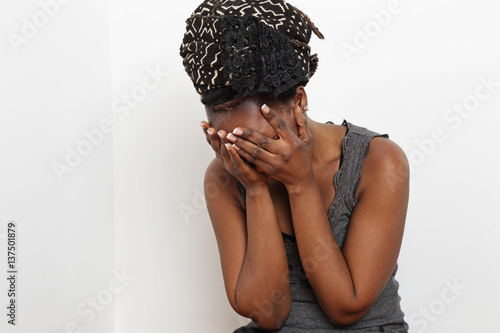 Принти на полотні jeune femme noire africaine en souffrance, pleurant contre un mur