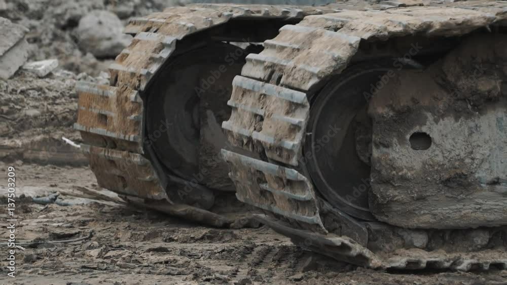 Close up caterpillar tracks of buiding machinery riding on dirt at building site Close up caterpillar tracks of buiding machinery riding on dirt at building site