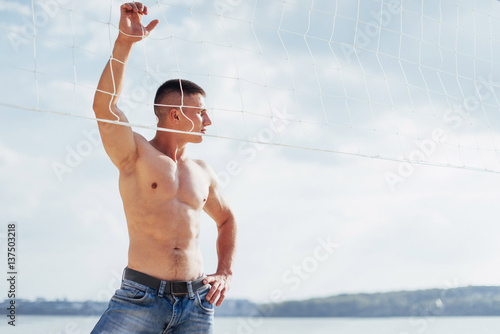 muscular male model with perfect body posing in blue jeans