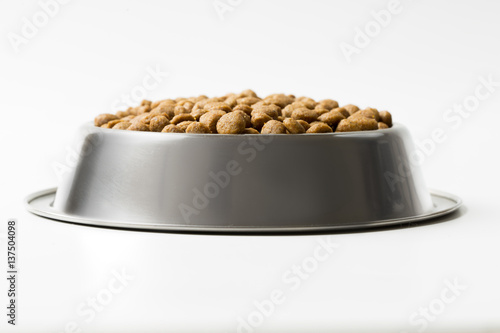 dry pet food in a metal bowl isolated on white background